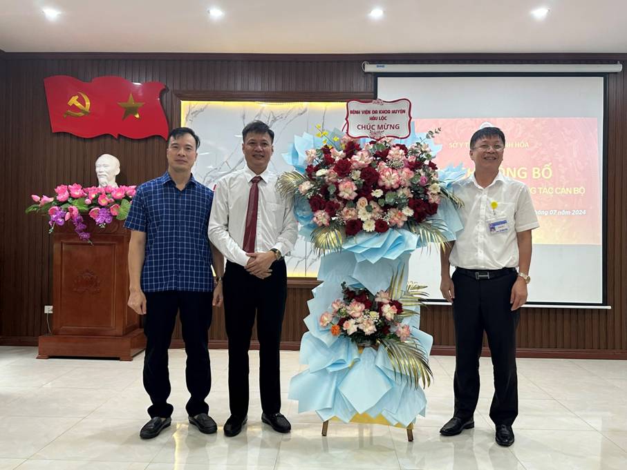 A group of men standing in front of a podium with flowers

Description automatically generated